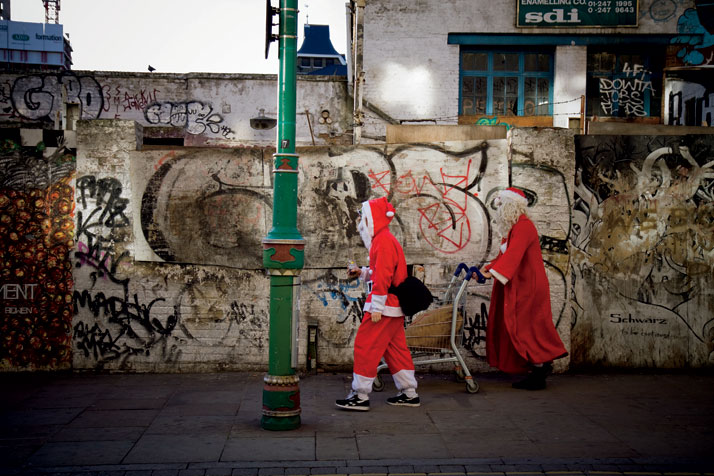 December  2011 // Men in Santa Claus outfits walk with a shopping cart along  Brick Lane after SantaCon: &#039;a non-proï¬t, non-political, non-religious 