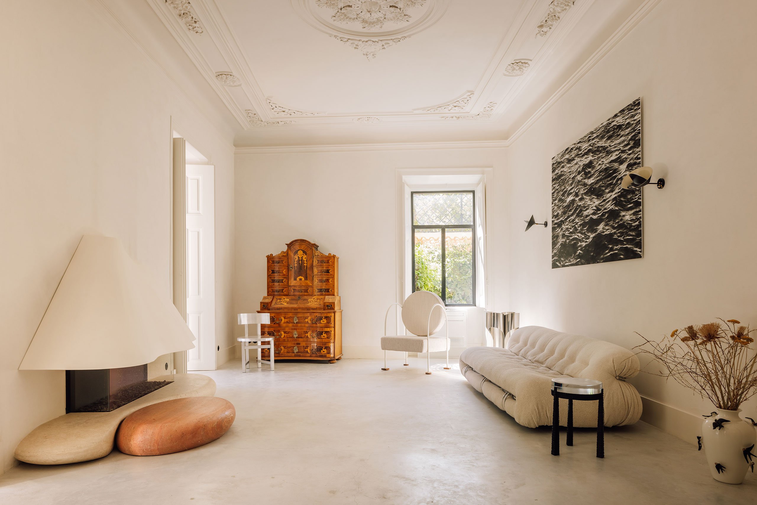 Bespoke fireplace, white and red travertine base and lacquered metal hood; 'AI203 Alumina Chair' by Studio Gameiro; Antique cabinet; ‘Capsule Armchair’ by Studio Gameiro; ‘Soriana’ sofa by Afra and Tobia Scarpa; ‘MIRRA’ Black Side Table by HAMREI; ‘Saturn Wall Sconces’ by Serge Mouille; Artwork by Teresa Esgaio.
Photography by Francisco Nogueira.