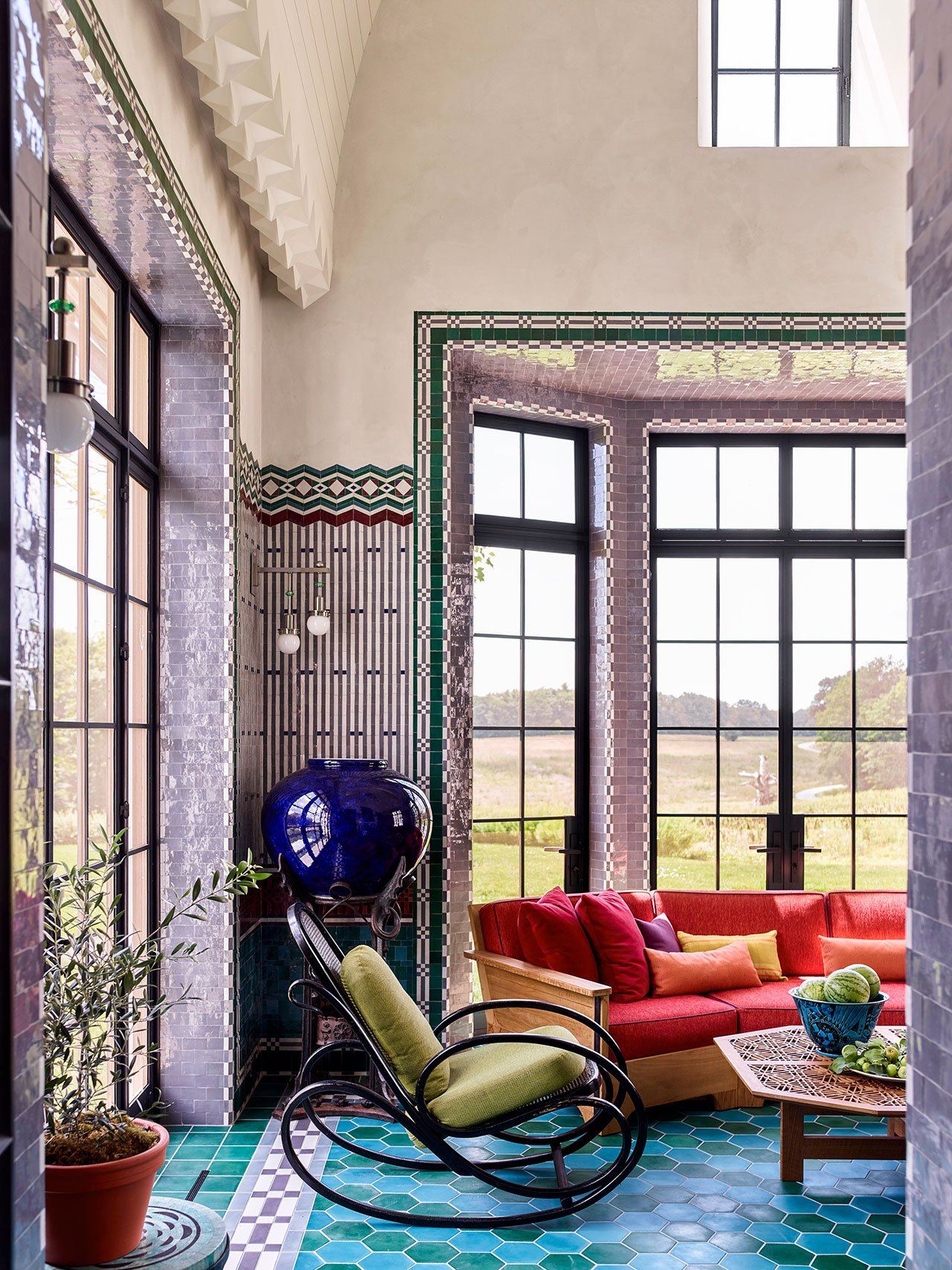 The walls of the screened porch are clad in green, burgundy, gray, and purple Moroccan zellige tiles in patterns inspired by the work of Koloman Moser and Joseph Urban.
Photography by Eric Piasecki.