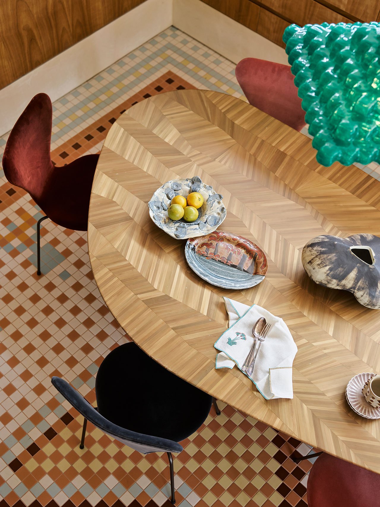 ‘Egyptian Hand Laid Bronze Straw Dining Table’ by Shewekar Elgharably; ‘Series 7 Velvet’ dining chairs by Arne Jacobsen for Fritz Hansen; ‘Archae Pendant Lamp n.411’ by Las Ánimas from Adorno; Porcelain Tiles from Ocean &amp; Merchant laid in custom pattern by YSG Studio.
Photography by Anson Smart.