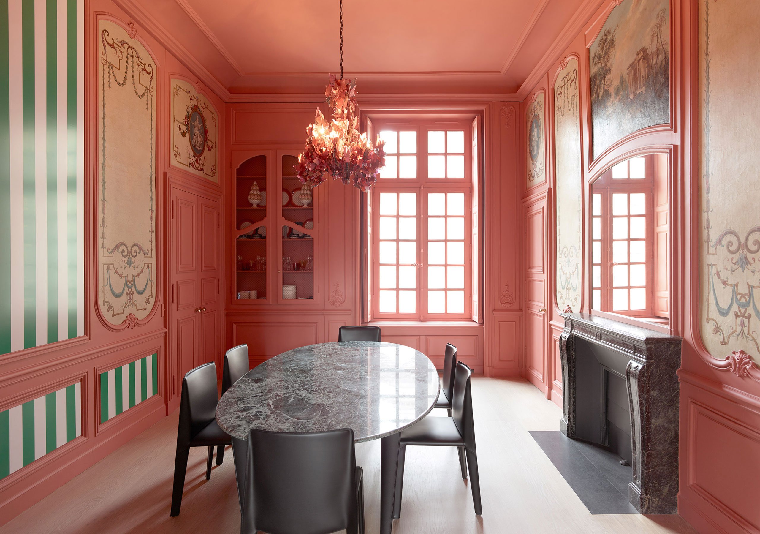 ‘Métiers’ oval dining table by Enzo Mari for Hermès; 'Cab' chairs by Mario Bellini for B&amp;B Italia; Bespoke glass chandelier by Nathalie Ziegler from Galerie Mougin; Striped mural by Daniel Burren.
Photography by Tommaso Sartori.