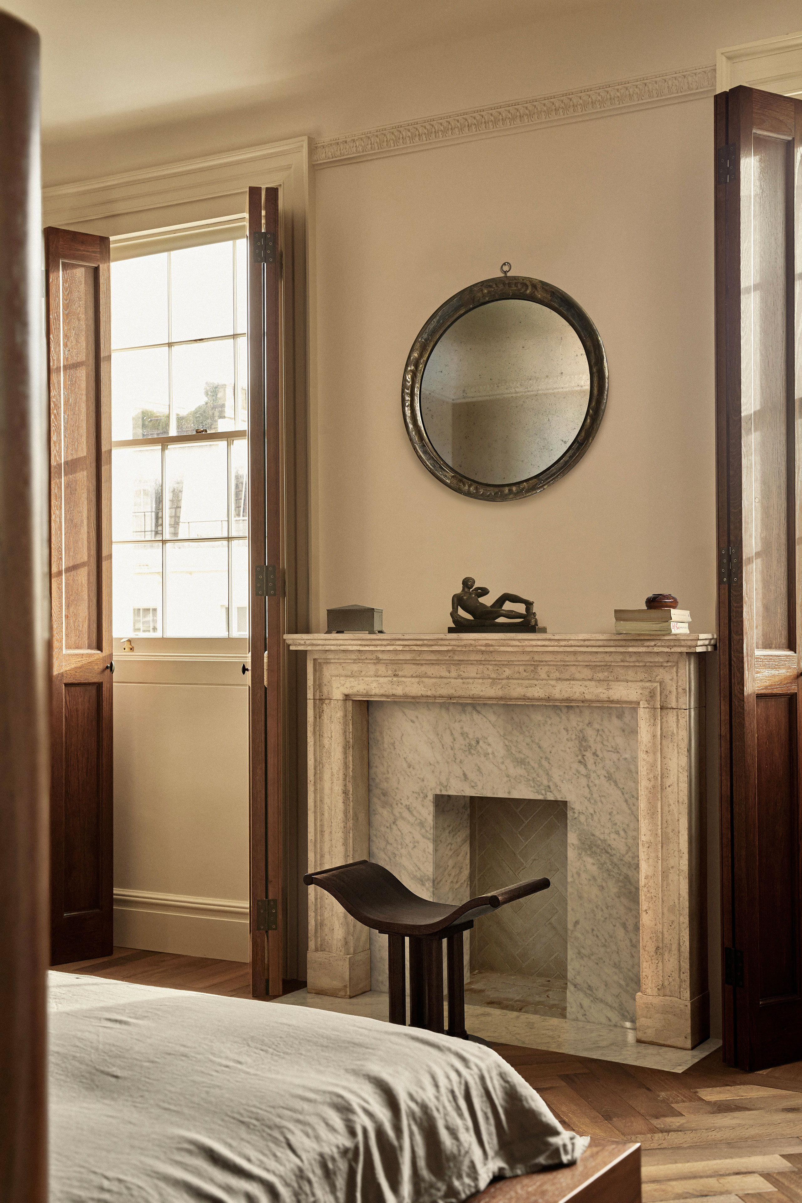 Antique mirror. Window shutters &amp; stool: Custom design by Child Studio. Georgian 19th-century marble and travertine fireplace. Antique mirror. Sculpture: Reclining nude by Aristide Maillol.
Photography by Helen Cathcart.