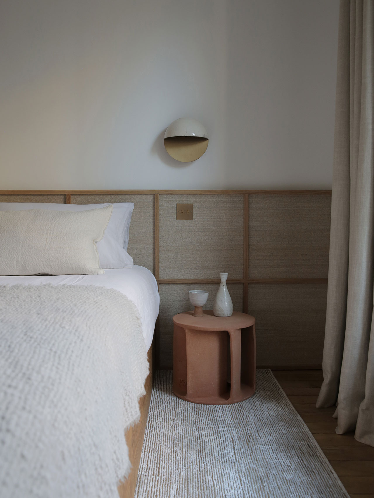 Bedhead in oak and thin rattan wallpaper by Emmanuelle Simon.
Sconce in raku and brass by Emmanuelle Simon.
Illuminated side table in in earthware by Guy Bareff.
Photography by Damien de Medeiros.