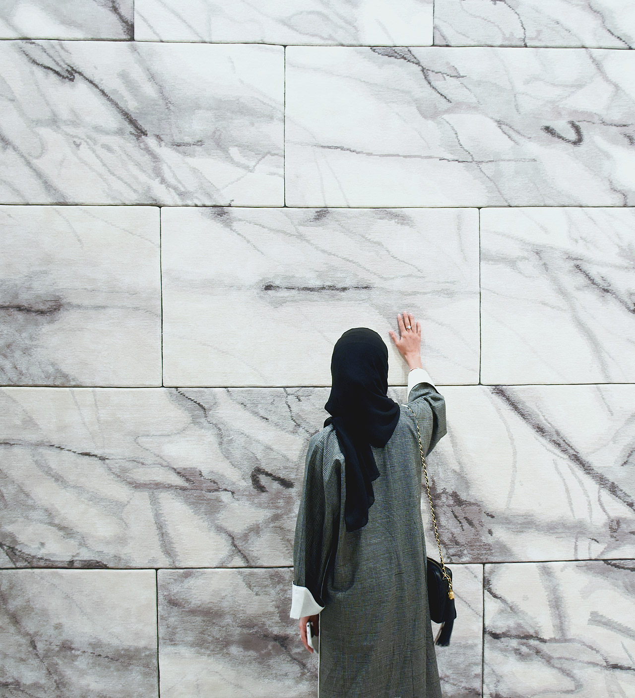 Dubai-based designer Aljoud Lootah interacts with the softest marble tiles in the world from the Floor to Heaven series by Michaela Schleypen at Samovar Carpets during Downtown Design Dubai 2016.