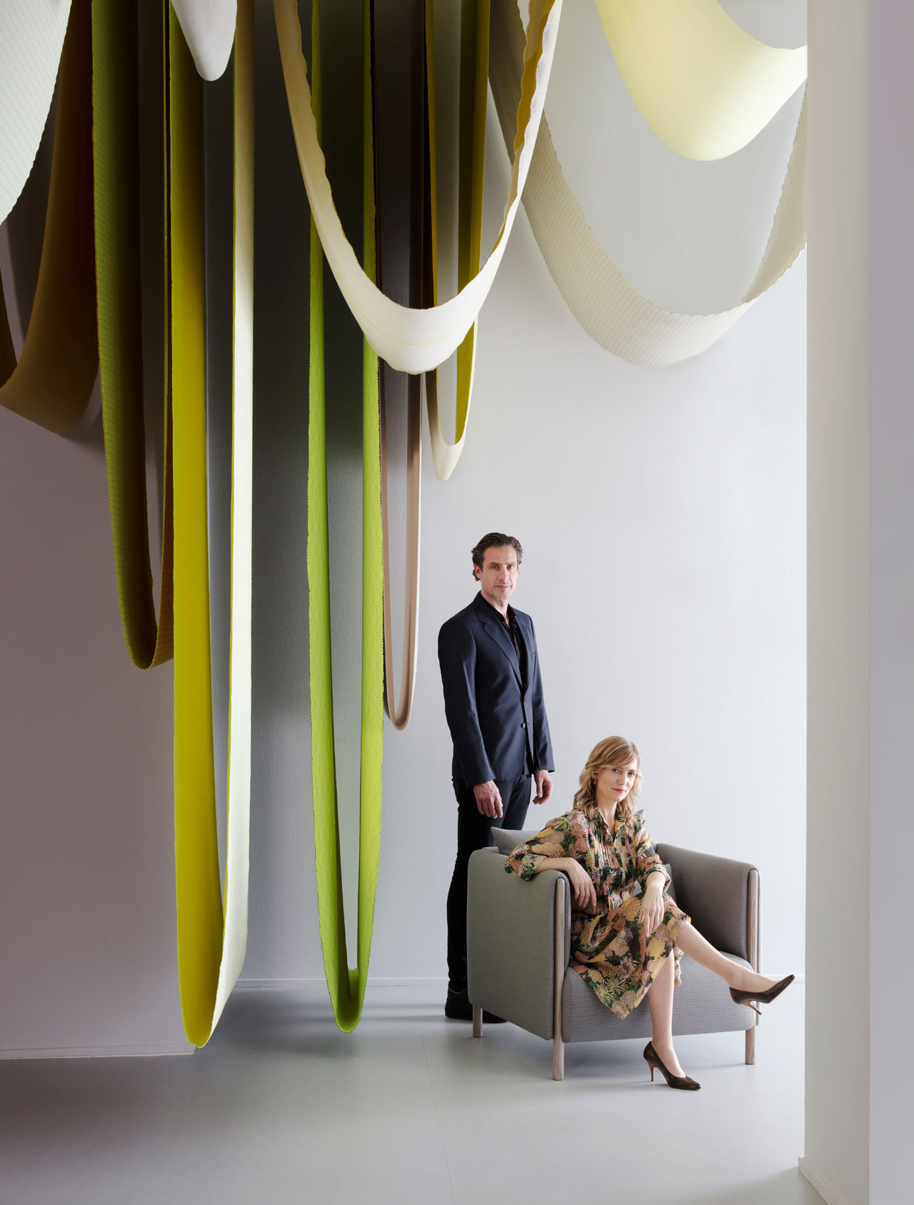 Chromatography exhibit by Stefan Scholten and Carole Baijings of Scholten &amp; Baijings in the Herman Miller featuring Mahatma textiles that were hanging from the ceiling, and beneath them elements of their new ColourForm Sofa Group for Herman Miller.Photo by Ben Anders.