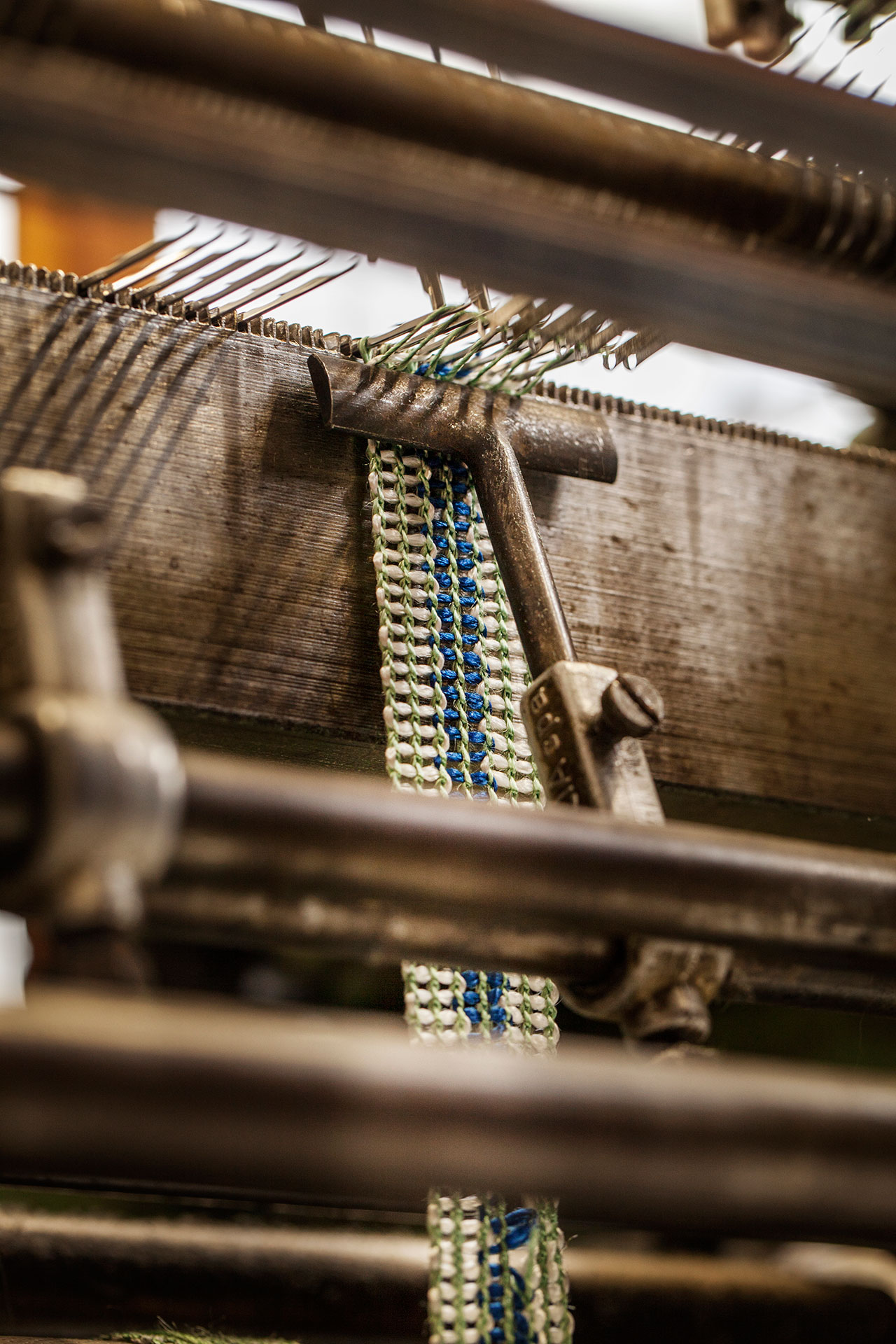 Athens. The Mentis ribbon weaving company. Detail of the production with the old braiding machine. © Benjamin Tafel.